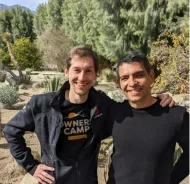 Juampy and Salvador smiling and standing outside in front of a desert forest landscape.